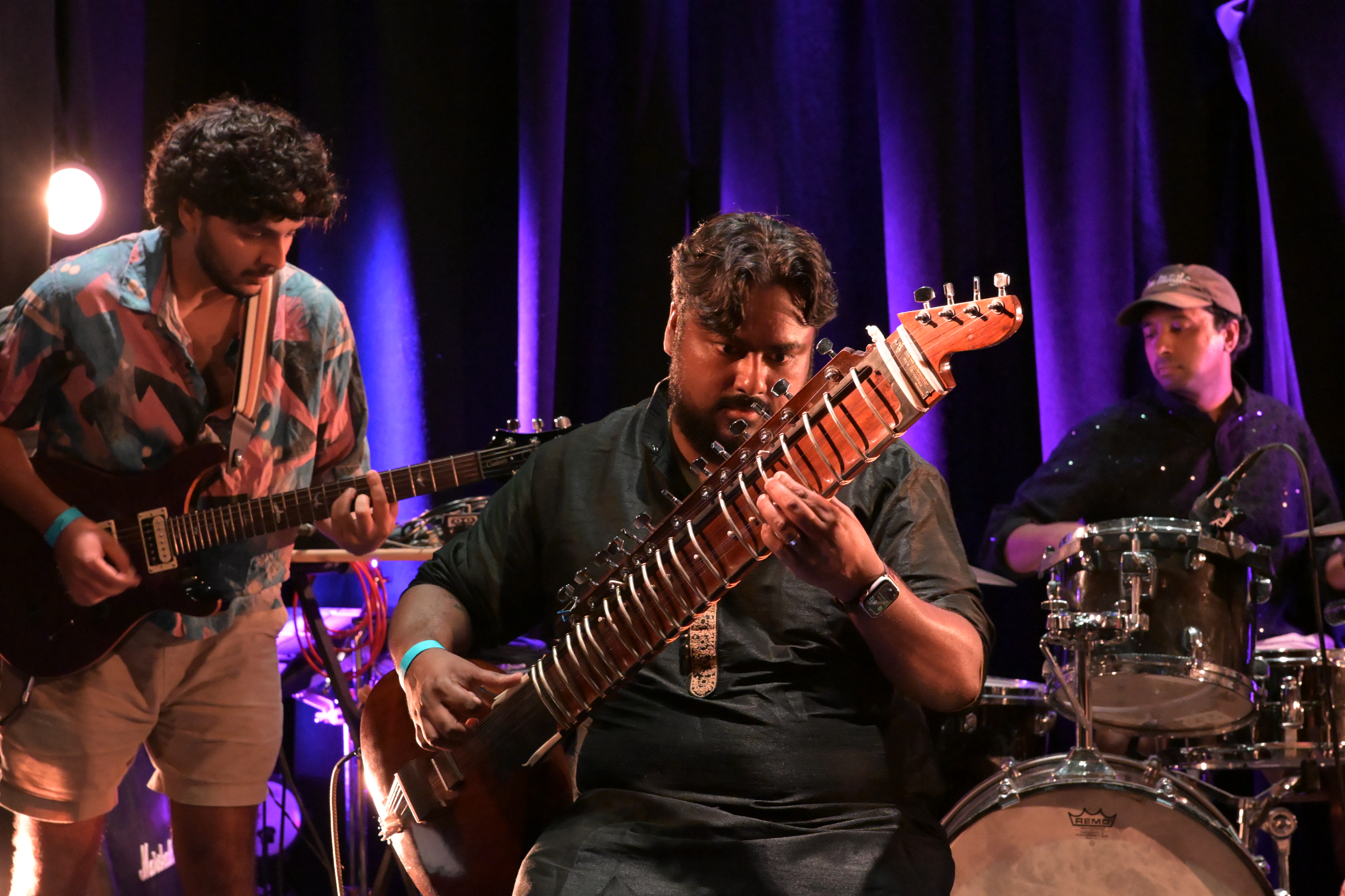 Mat on sitar under purple stage lights